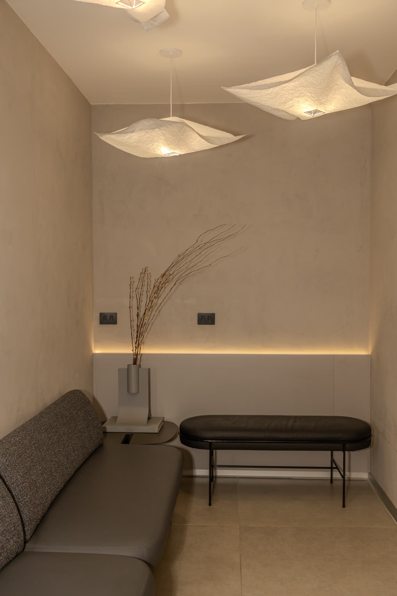 Sala de espera da clínica, com poltronas e iluminação indireta