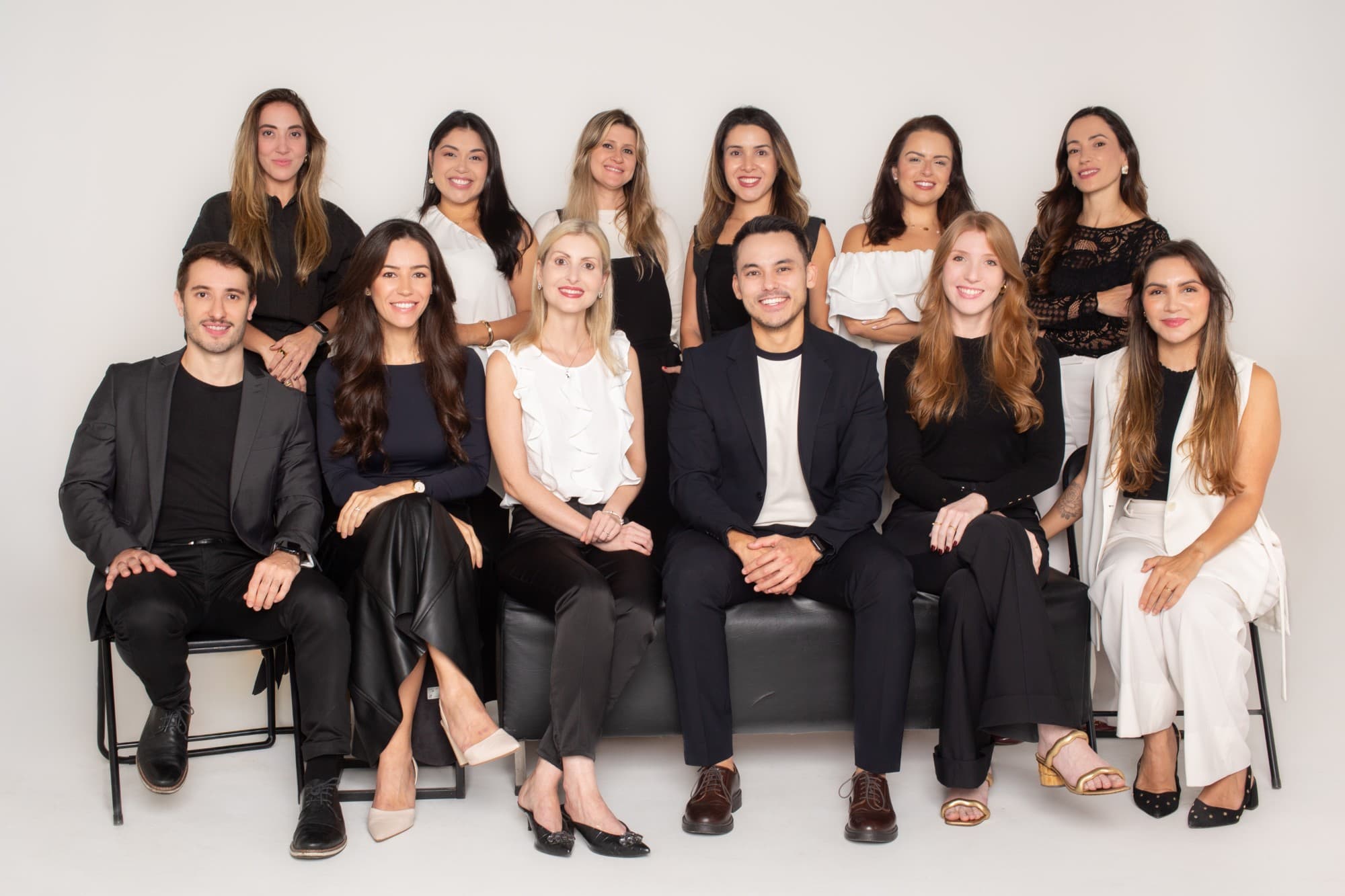 Os doze dermatologistas da Yamagata Dermatologia reunidos em duas fileiras, em fundo claro