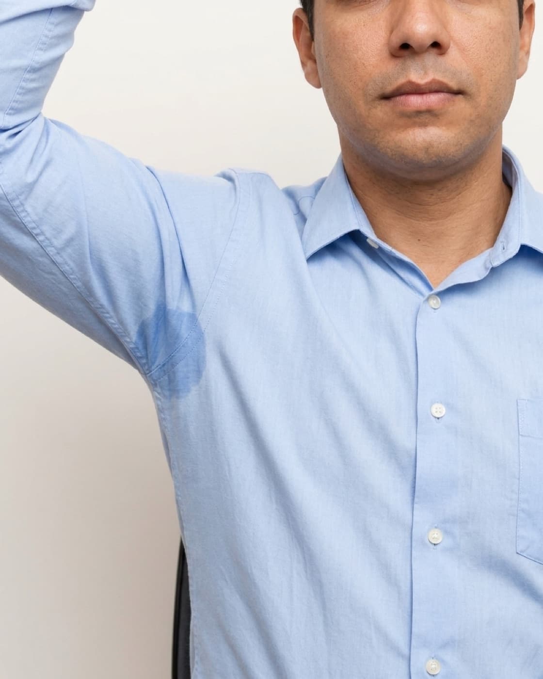 Homem de camisa social com marca de suor na axila