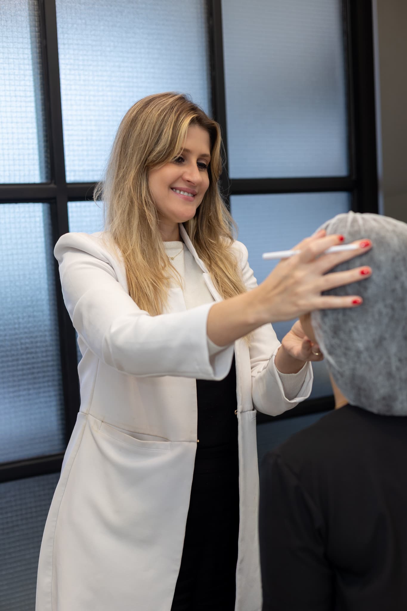 Dermatologista faz a marcação no rosto de uma paciente para o planejamento do procedimento